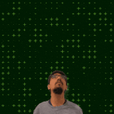 a man with glasses stands in front of a green background with the number 3 + 0