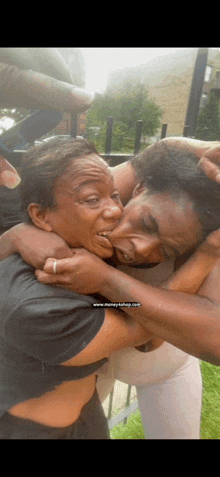 a woman is making a face while hugging another woman .