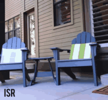 two blue adirondack chairs are sitting on a patio in front of a house with the word isr below them