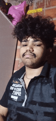 a man with curly hair and a beard wears a black shirt that says rock 'n ' roll on the front