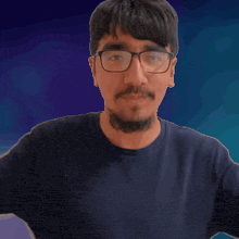 a man with glasses and a beard covering his ears with his hands