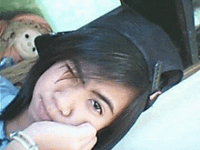 a young girl wearing a hat is laying on a bed .