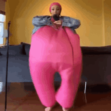 a woman in a pink costume is standing in a living room .