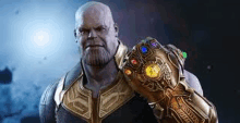 thanos from avengers infinity war is holding a infinity gauntlet .