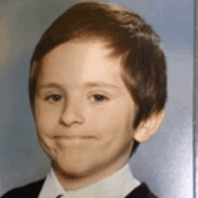 a young boy is making a funny face in a school photo .