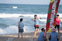 a group of people on the beach with a banner that says team building