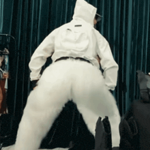 a person wearing white pants and a white jacket with a hood on