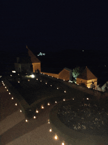 a night time view of a building with candles on the ground