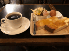 a cup of coffee sits next to a plate of food