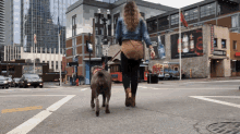 a woman is walking a dog on a leash in front of a building with a billboard for jack daniels on it