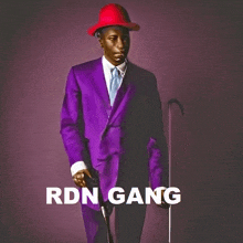 a man in a purple suit and red hat is standing with a cane in front of the word gang