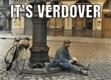 a man sits on a curb with the words it 's verdover behind him