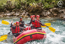 a group of people are rowing a red raft with the number 9 on it