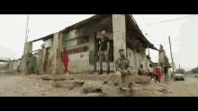 a group of people are standing in front of a building with a sign that says ' barber shop ' on it