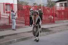 a man in a native american costume is walking down a sidewalk