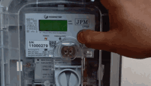 a person is pressing a button on an jpm meter