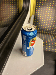 a can of feldschlöss pilsner sits on a train table