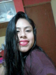 a woman with long black hair and red lipstick is smiling for the camera