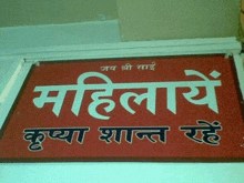 a red sign that says ' mahilaye ' on it in white letters