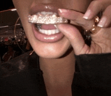 a close up of a woman 's mouth with a grill in her mouth .