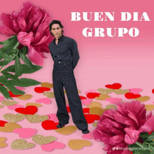 a man stands in front of a pink flower with the words buen dia grupo written on it