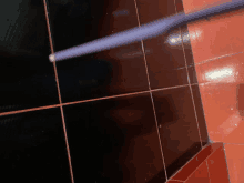 a black and red tiled floor with a purple stick in the corner