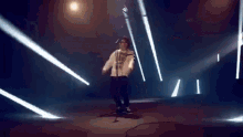 a person is dancing in a dark room with a lot of lights coming from the ceiling