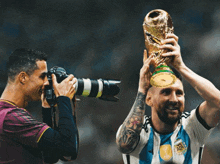 a man is taking a picture of a man holding a trophy