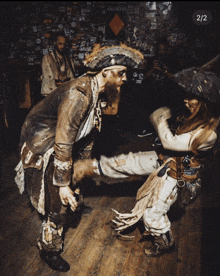 a man in a pirate costume holds another man 's leg in front of a sign that says salman