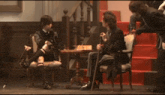 a man sitting in a chair playing chess with a cane