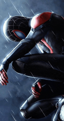 a man in a spiderman costume is kneeling down in the rain