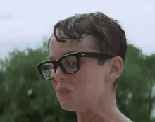 a close up of a person wearing glasses and a wet hair