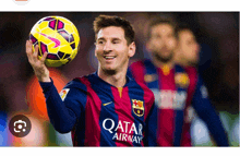 a soccer player wearing a qatar airways jersey holds up a soccer ball