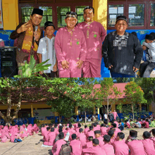 a group of people in pink shirts are sitting in front of a building