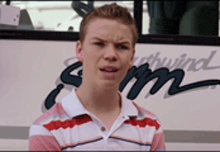 a young boy is standing in front of a bus that says southwind