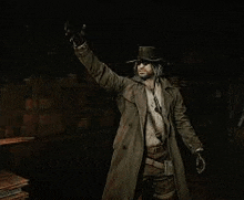 a man in a trench coat and top hat is standing in a dark room with his hand up .