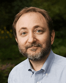 a man with a beard wearing a light blue shirt