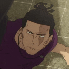 a man in a purple shirt is laying on the floor with his head in a bun .