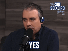 a man wearing headphones and a shure microphone says " yes "