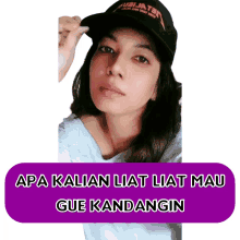 a woman wearing a black hat with the words apa kalian liat liat mau gue kandangin on the bottom