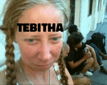 a woman with braids has the word tebitha written on her forehead