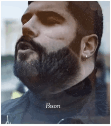 a close up of a man with a beard and the word buon below him