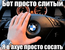 a person 's hand is on the steering wheel of a bmw car