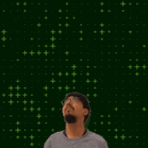 a man stands in front of a green background with the number 20 in yellow