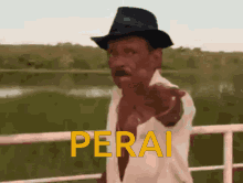 a man wearing a hat points to the word perai in yellow letters