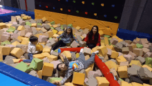 a group of children are playing in a foam pit