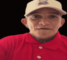 a man wearing a red shirt and a white hat with a cartoon on it