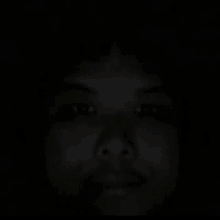 a close up of a person 's face in a dark room