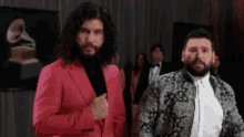 a man in a pink suit is standing next to another man