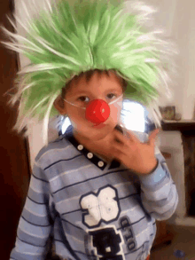 a young boy wearing a green wig and a red nose is wearing a shirt with the number 36 on it